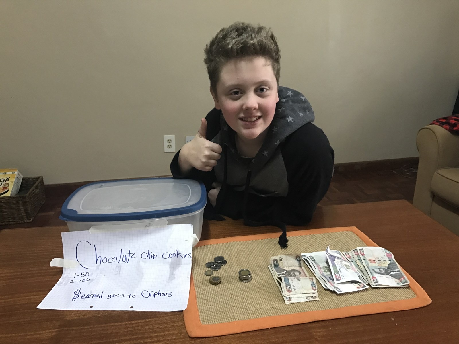 Mason, age 13, with his cookie box and the money from his sales